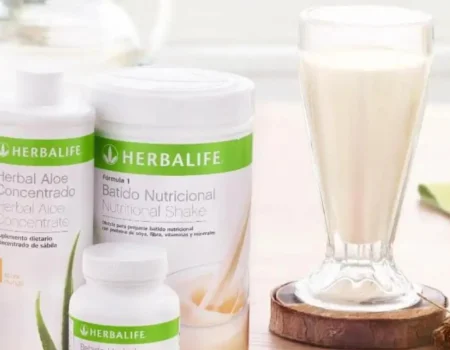 Productos Herbalife para un Peso Saludable acompañados de frutas frescas en una mesa, destacando la naturalidad y los beneficios nutricionales.
