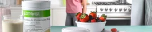 mujer tomando un vaso de batidos y proteinas herbalife