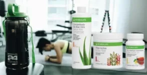 los 3 prodcutos que componen la bebida taf de herbalife junto a un botellos de la marca