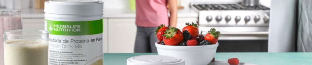 mujer tomando un vaso de batidos y proteinas herbalife