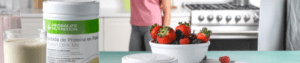 mujer tomando un vaso de batidos y proteinas herbalife