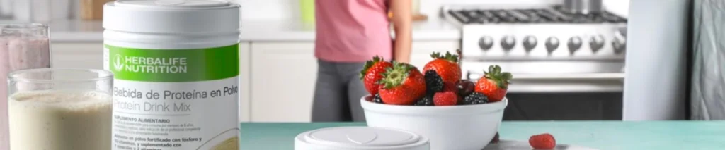 mujer tomando un vaso de batidos y proteinas herbalife